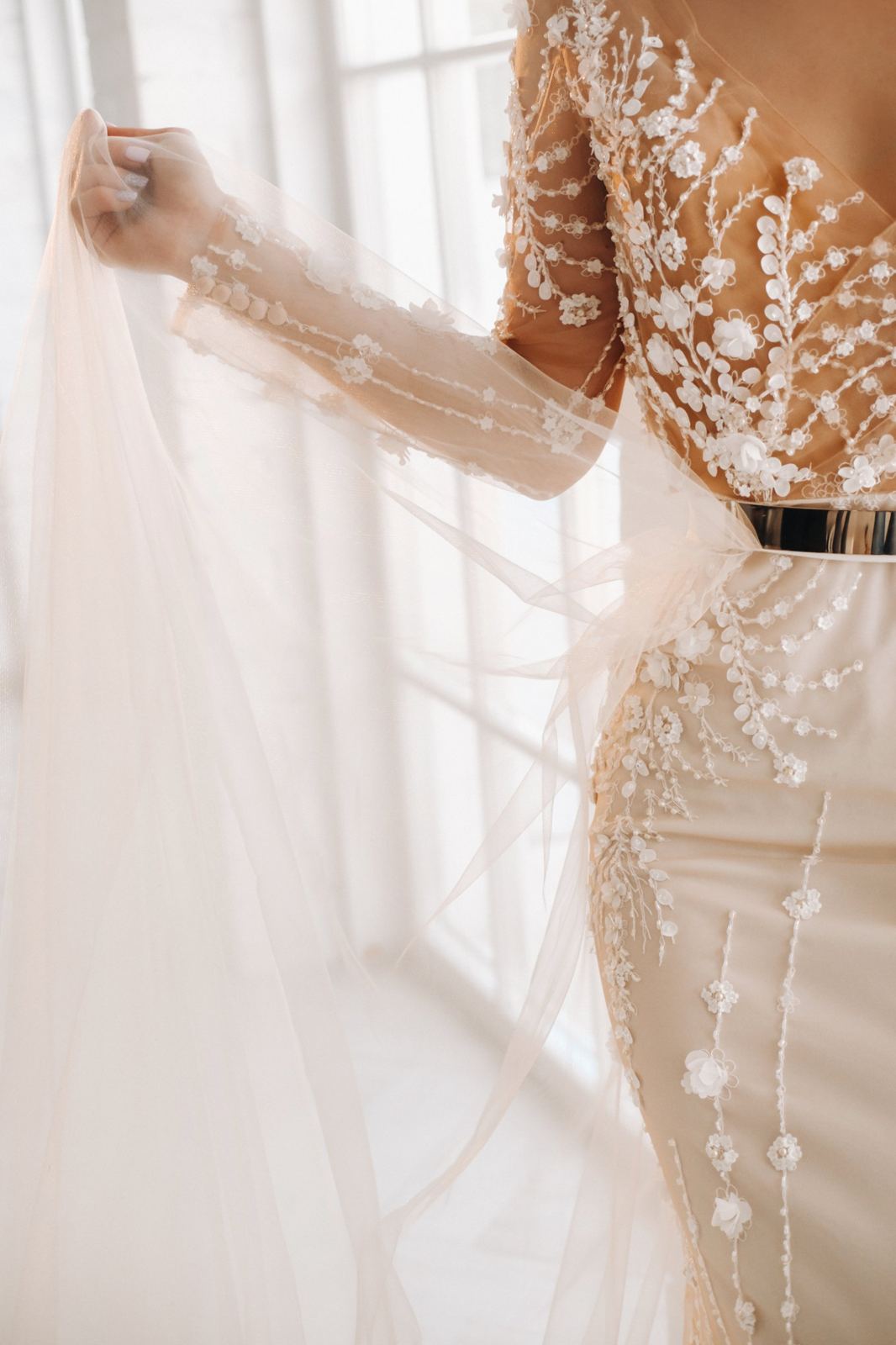 Detail of a beaded lace wedding dress and veil