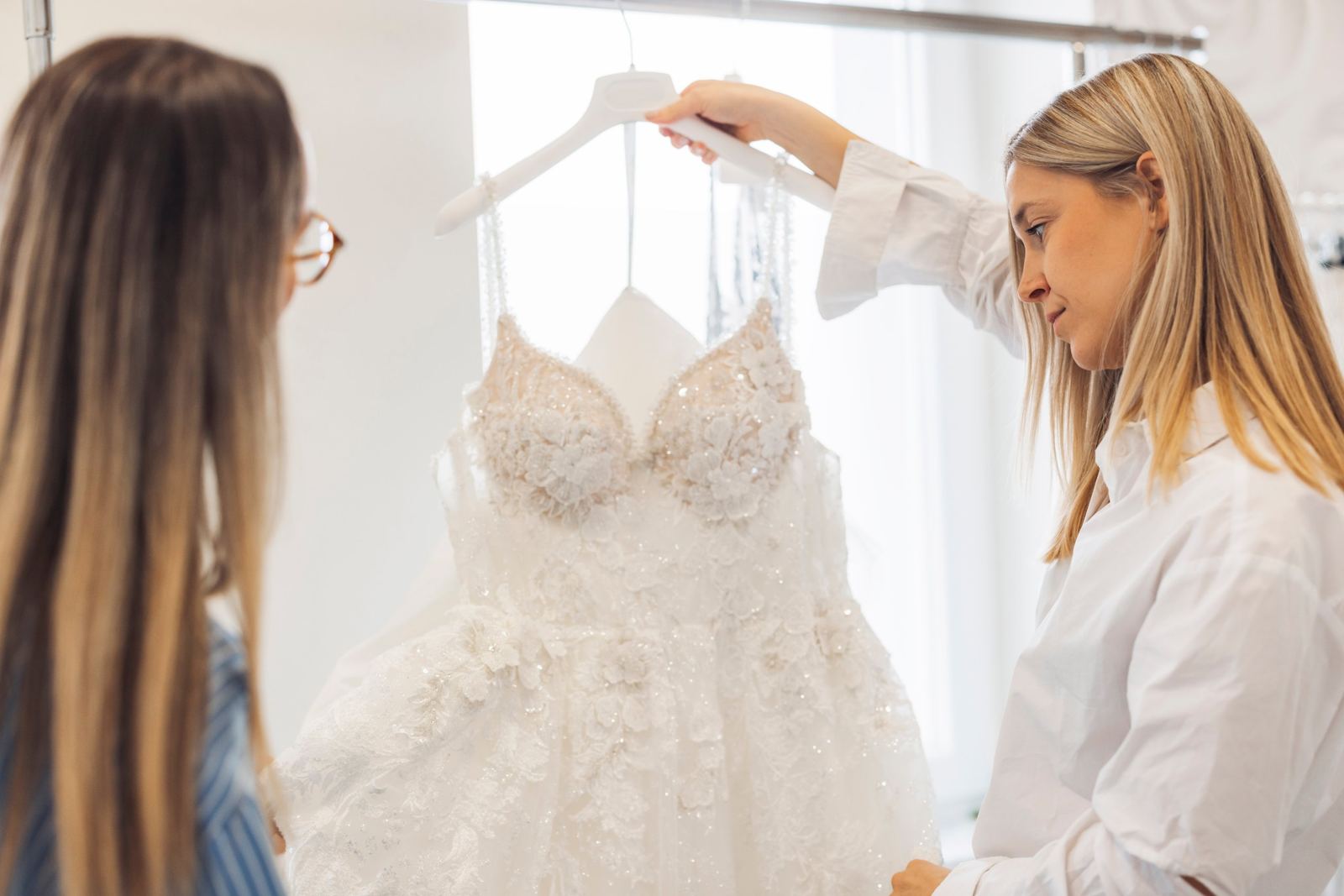 A wedding dress being checked on its hanger